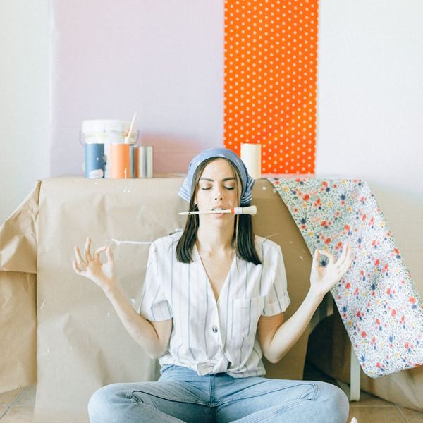 Person stretching gently in a brightly lit room with minimalist decor.